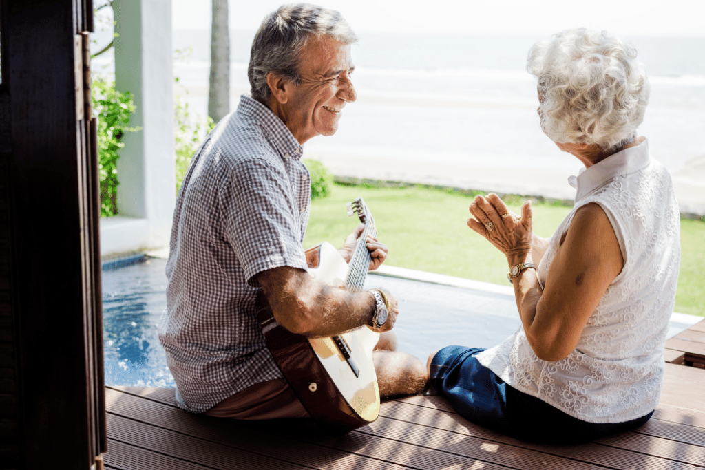 A happy retired couple playing music near a pool